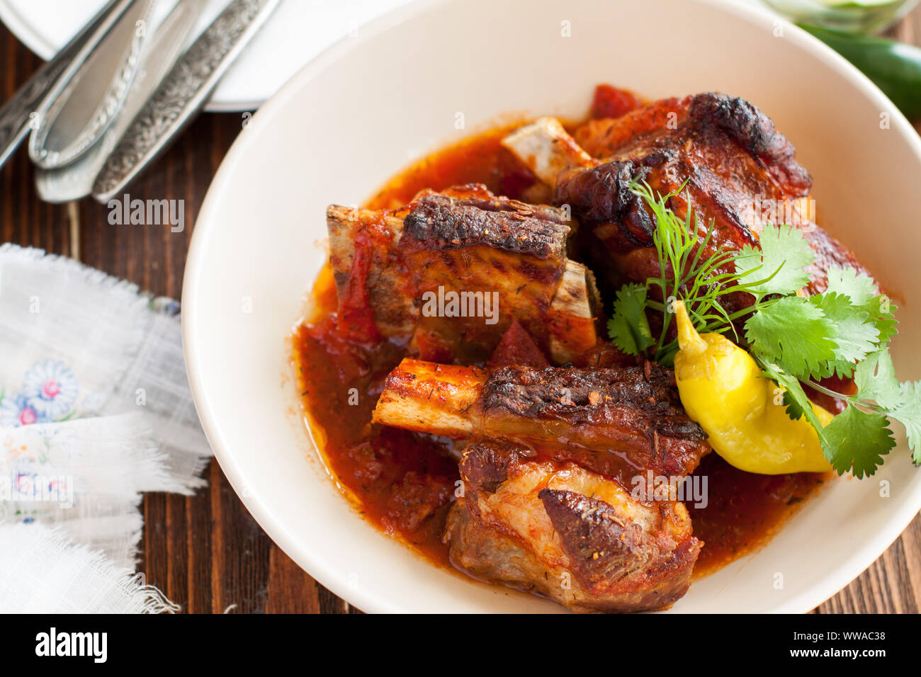 Gegrilltes Rindfleisch geschmorte Rippchen serviert mit Chili jalapeno und frischen Kräutern auf Holzbrett Stockfoto