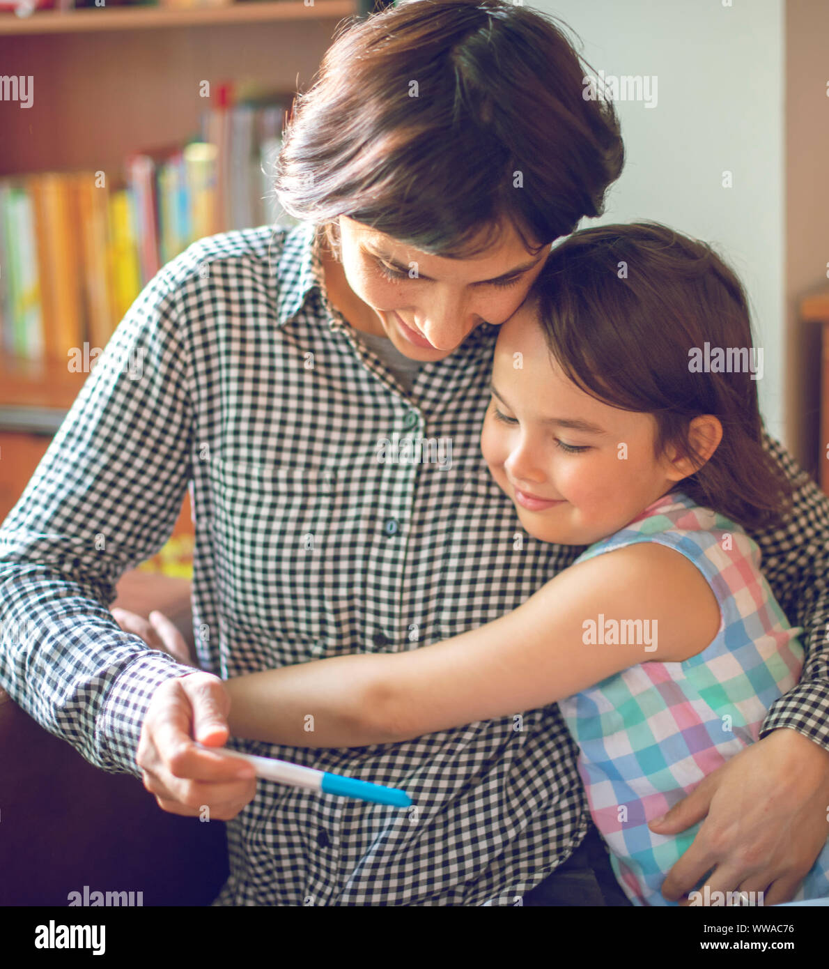 Mutter mit ihrer Tochter, während die positiven Schwangerschaftstest suchen Stockfoto