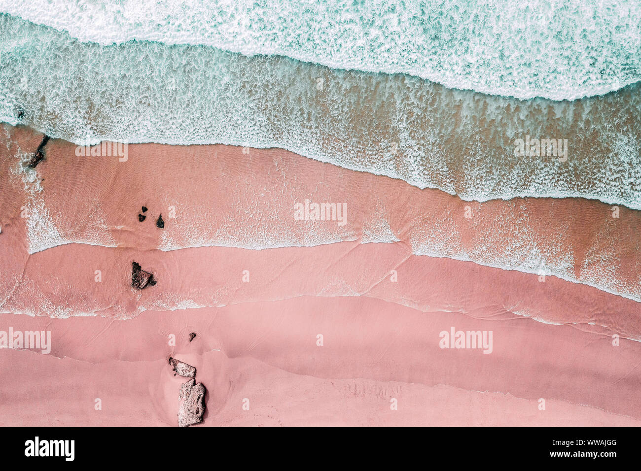 Luftaufnahme von Wellen und Schöne rosa Sandstrand Küste Stockfoto