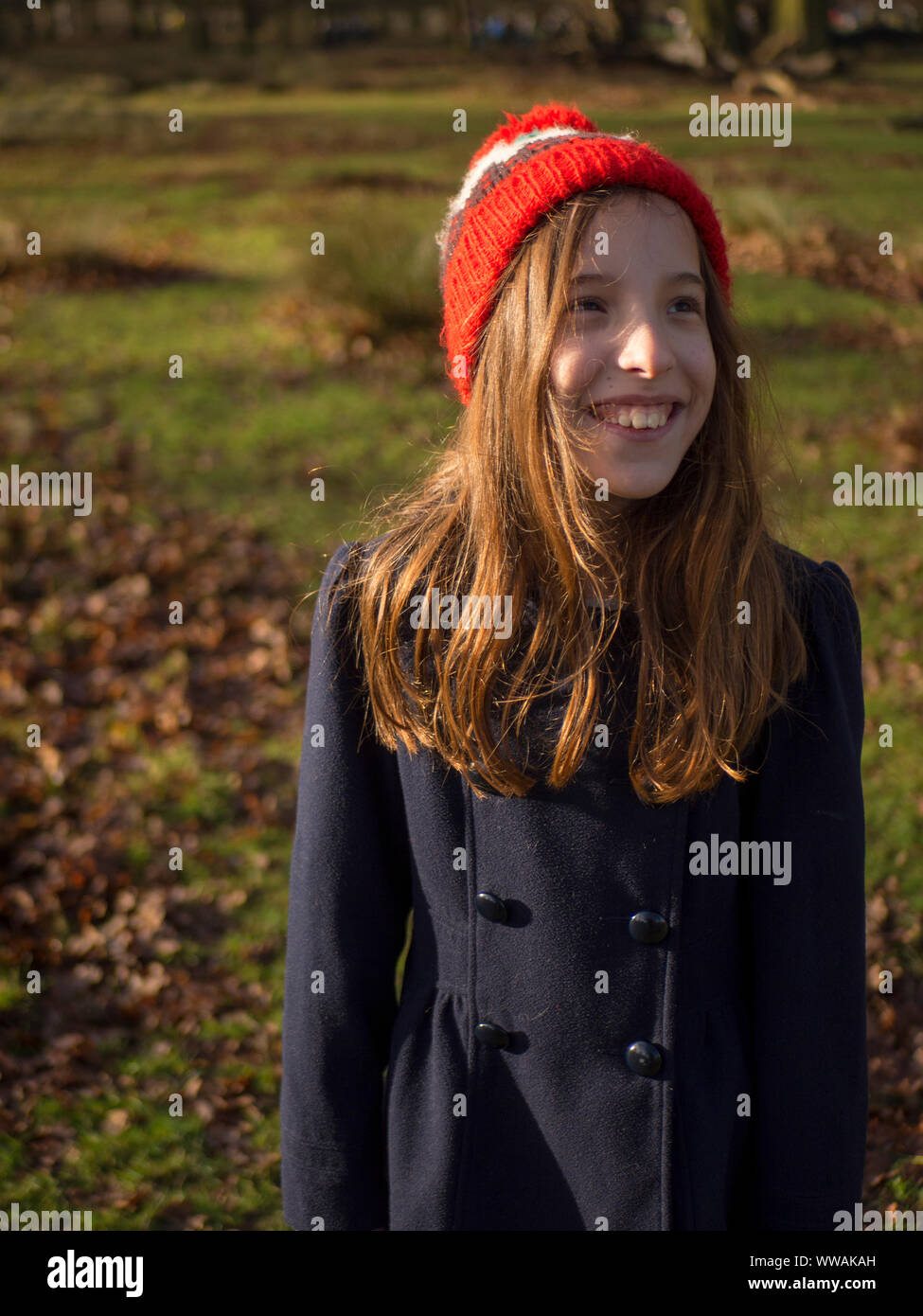 9 Jahre alte Mädchen mit einem bobble Hut auf einem herbstlichen Spaziergang in Cheshire, Großbritannien Stockfoto