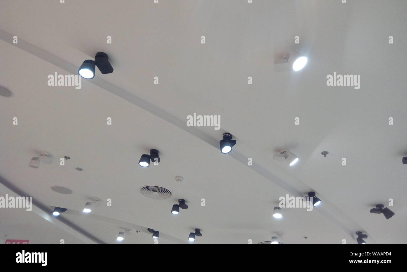 Gips abgehängten Decke Design mit nach unten Leuchten für eine Kleider aufbewahren Bei einer Shopping Mall Interieur Stockfoto