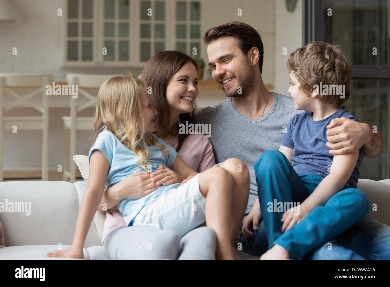 Glückliche junge Familie Paar halten in runde kleine niedliche Kinder. Stockfoto