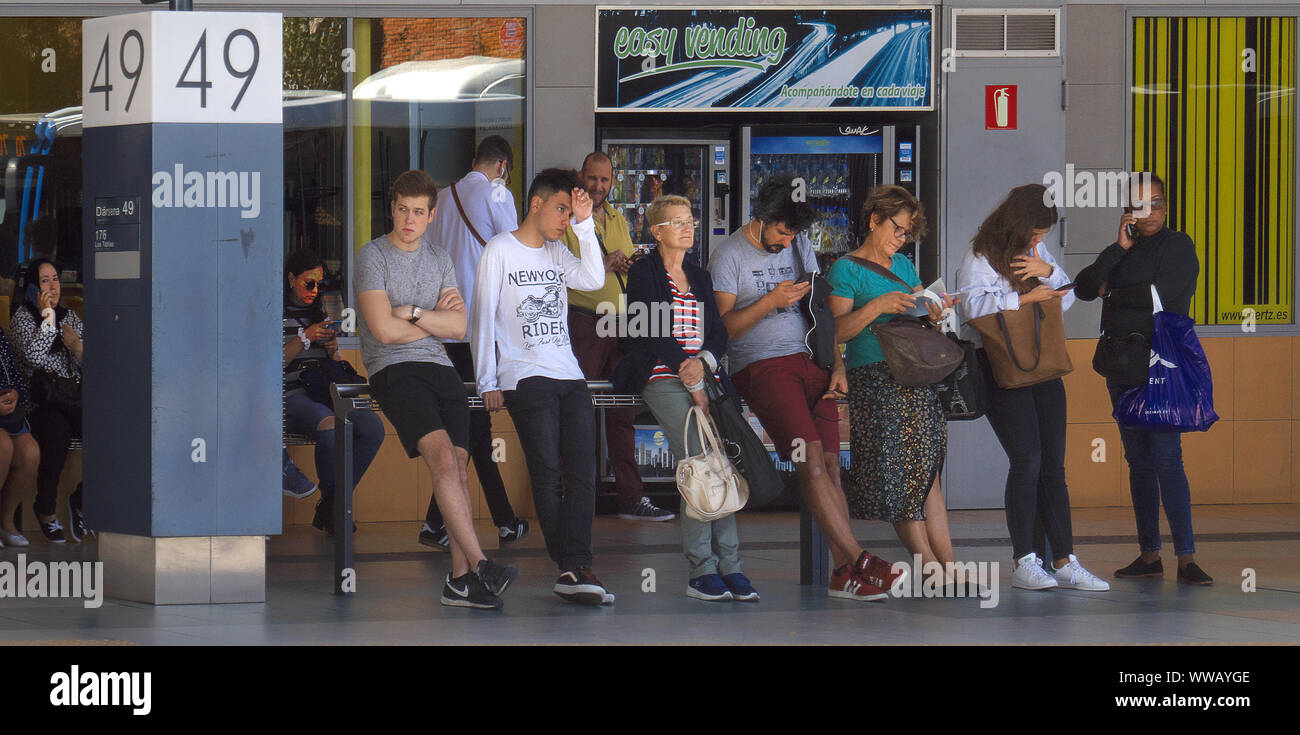 Menschen mit gemischtem Geschlecht und Alter, die in Madrid Schlange stehen, um in den Bus zu fahren. Stockfoto