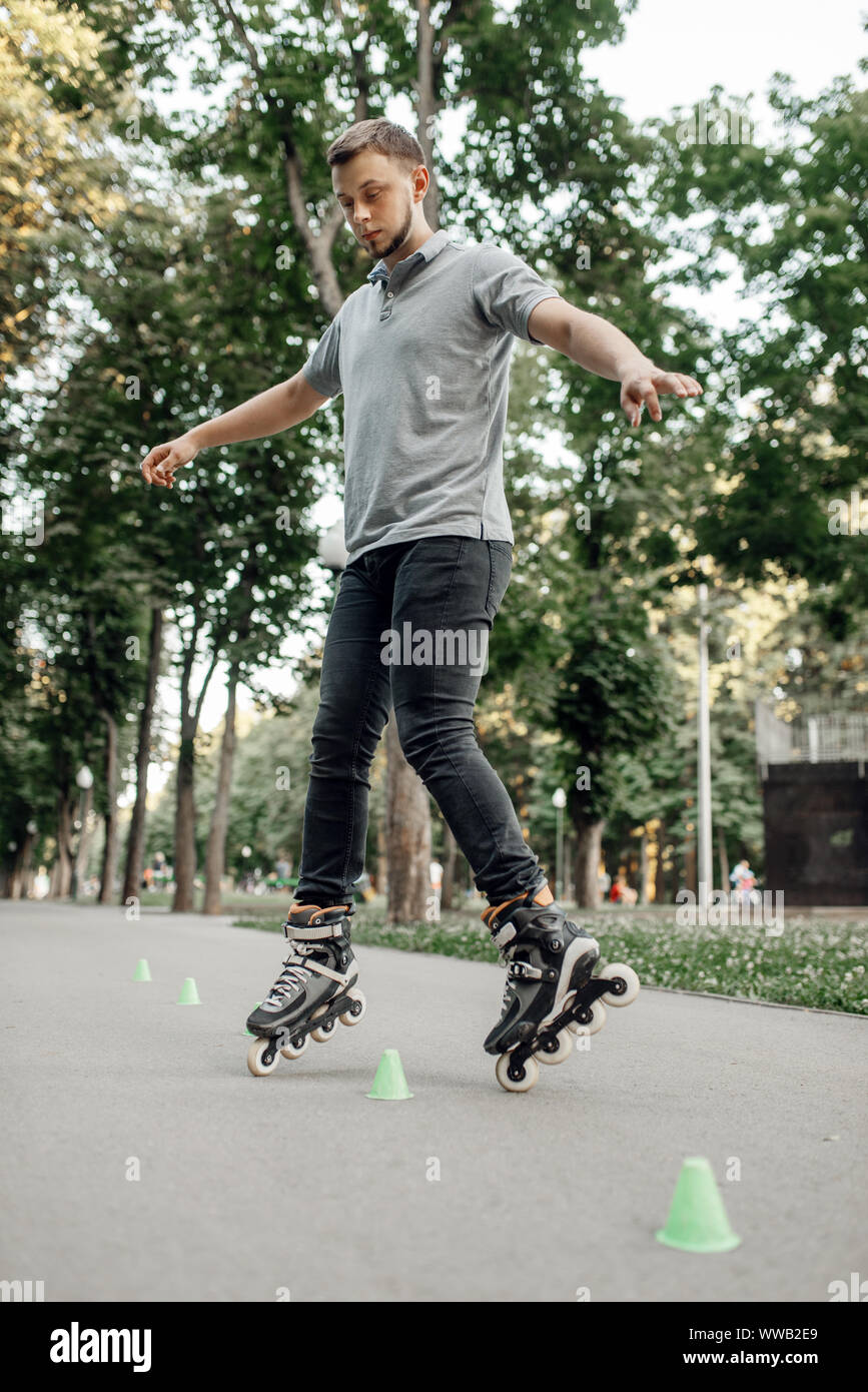 Roller Skating, Skater Rollen um die Kegel Stockfoto