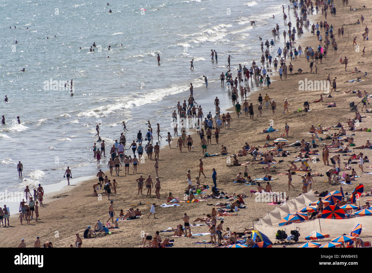 Playa del Ingles, Spanien - Jan 7, 2011: Viele Touristen entspannen und Wandern am Strand von Playa del Ingles Stockfoto