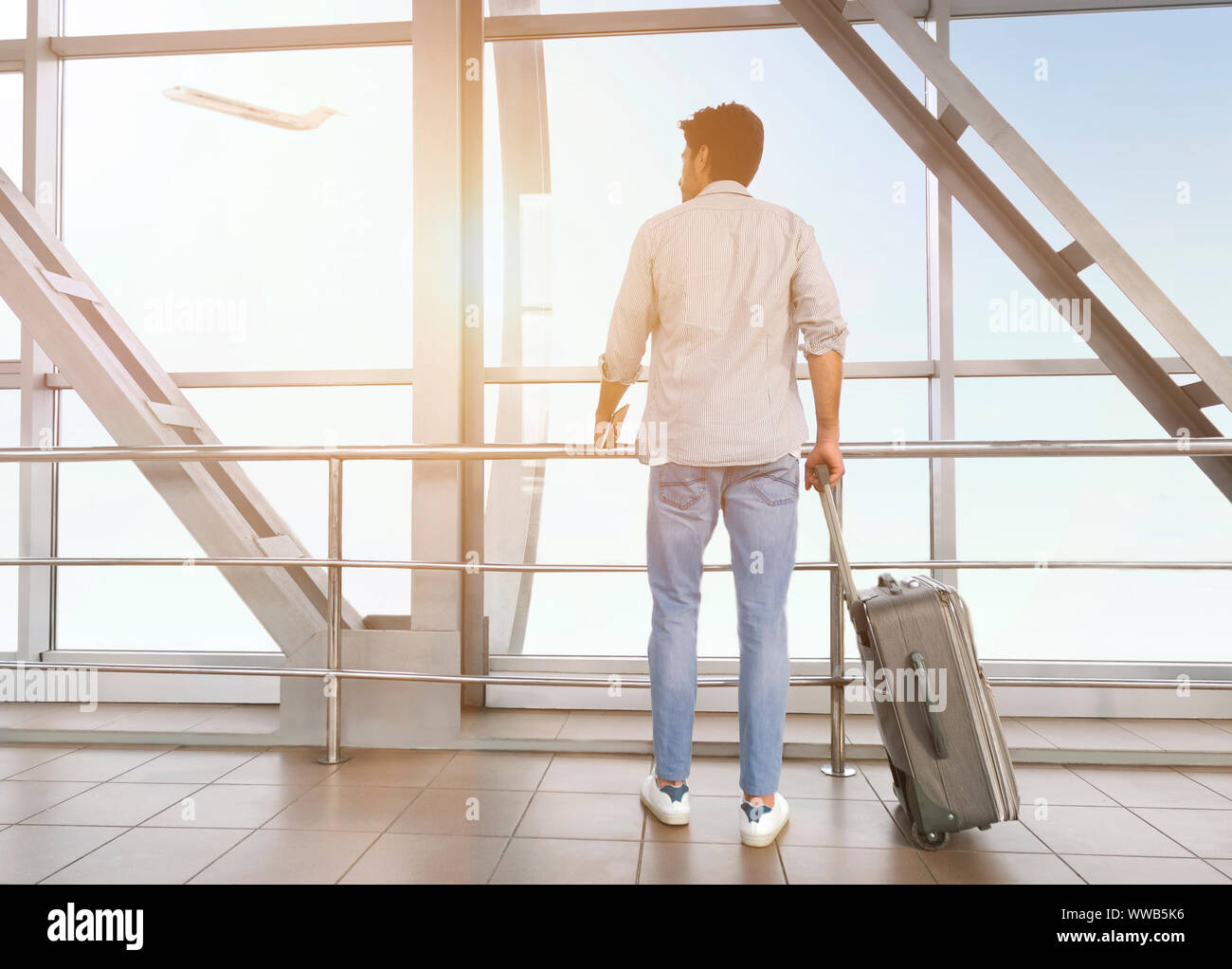 Junger Mann mit Gepäck am Flughafen genießen Fenster anzeigen Stockfoto