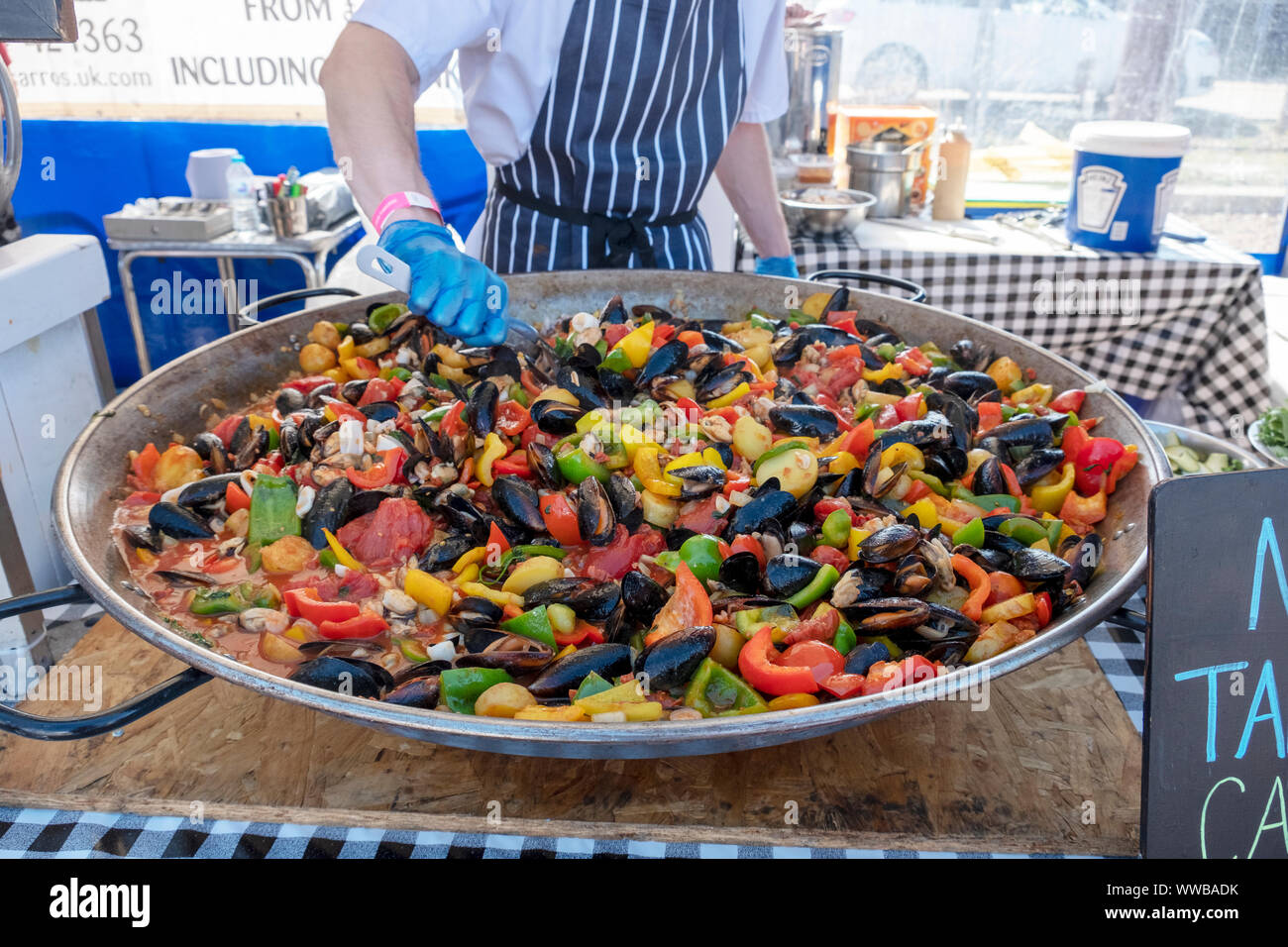 Köche aus pissaro's Restaurant ein bunter Paella bei der jährlichen Hastings Seafood Festival 2019 vorbereiten Stockfoto