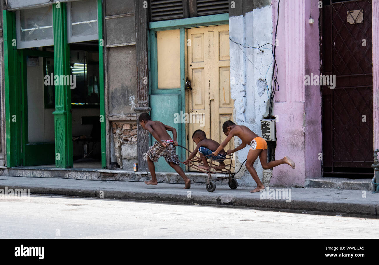 Jungen laufen auf einem Wagen auf der Straße in Havanna, Kuba Stockfoto