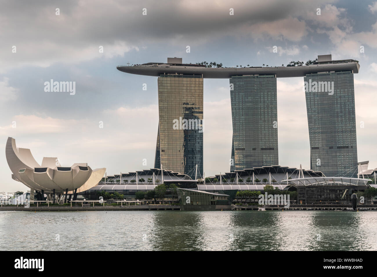 Singapur - März 20, 2019: Marina Bay Sands Hotel und Casino mit seinen drei Türmen von hinter der Bucht unter Öffnung cloudscape gesehen. Weißes Oberteil ist Kunst - Stockfoto