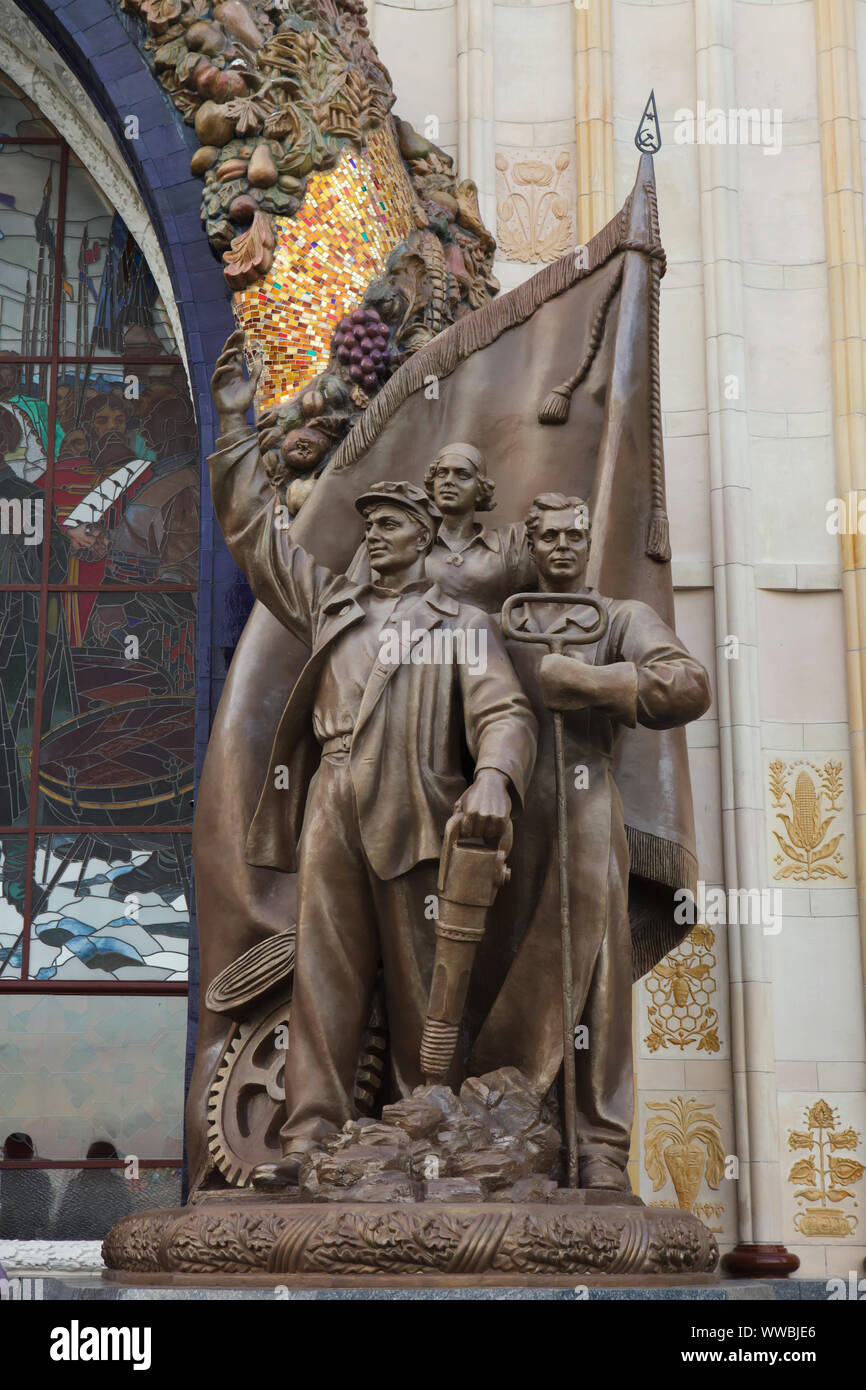 Statuen der Ukrainischen Arbeitnehmer flankiert der Haupteingang der Ukraine Pavillon im Messegelände VDNH (Ausstellung der Errungenschaften der Volkswirtschaft) in Moskau, Russland. Der Ausstellungspavillon von sowjetischen Architekten Alexej Tatsiy mit Hilfe von Valentina Chuprina und Grigori Shlaknev wurde 1954 gebaut. Es war auch später als die Landwirtschaft Pavillon verwendet. Stockfoto