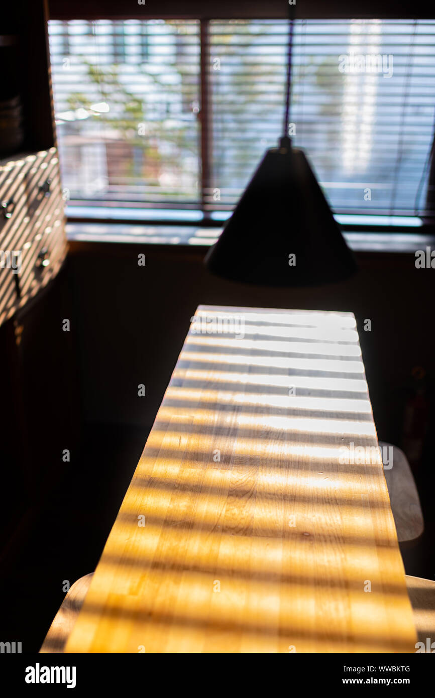 Traditionelle japanische Küche aus Holz Tisch mit beleuchteten lampe durch Fenster helles Sonnenlicht Licht und Schatten Stockfoto