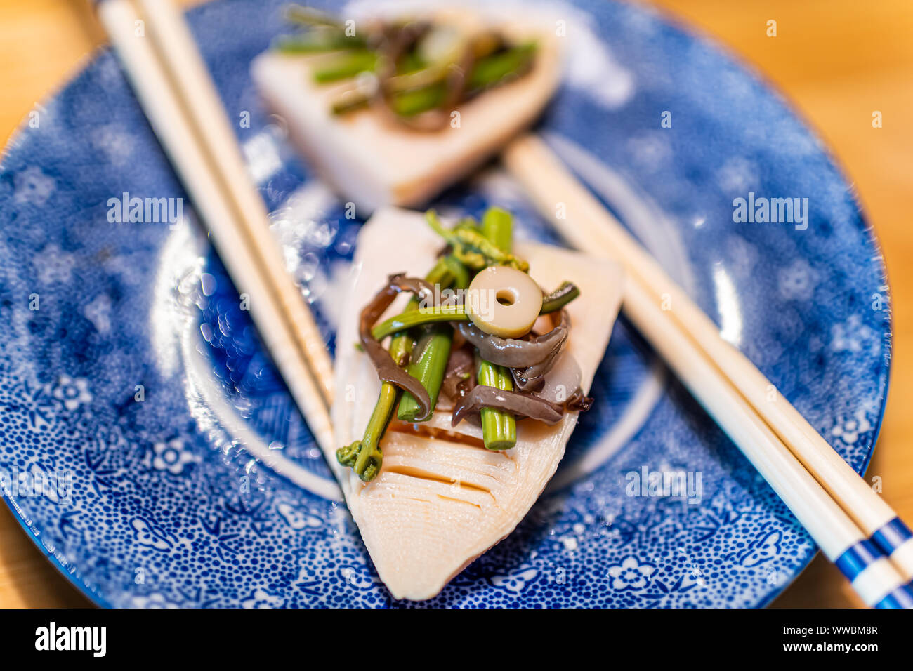 Traditionelle japanische blau Keramikplatte im Restaurant mit Holztisch und  Feder Gemüsegericht mit takenoko Bambussprossen und hanstedt Wildkräuter wi  Stockfotografie - Alamy