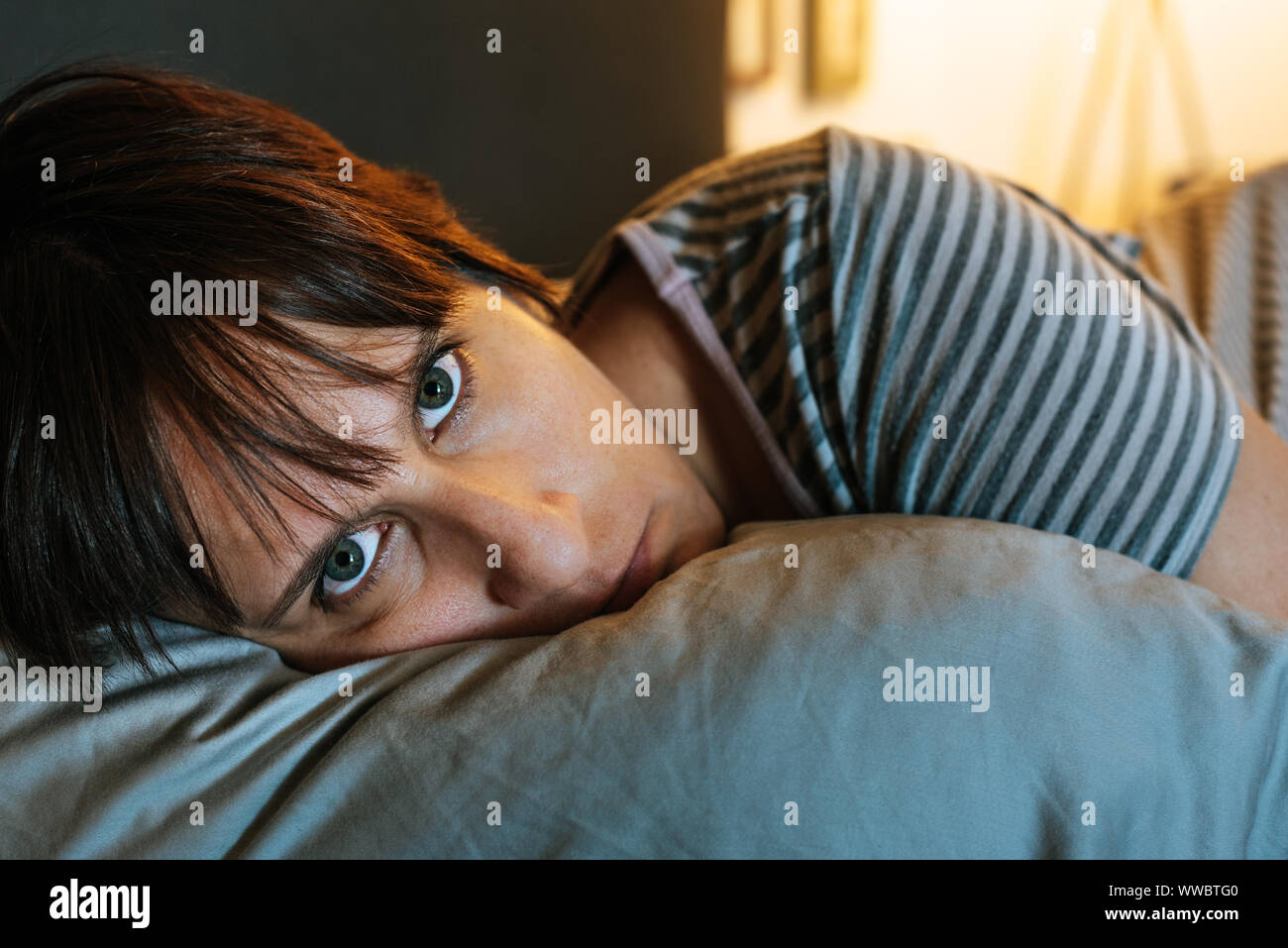 Weiße Frau im Bett in die Kamera starrte mit einem ernsten Gesicht. Stockfoto
