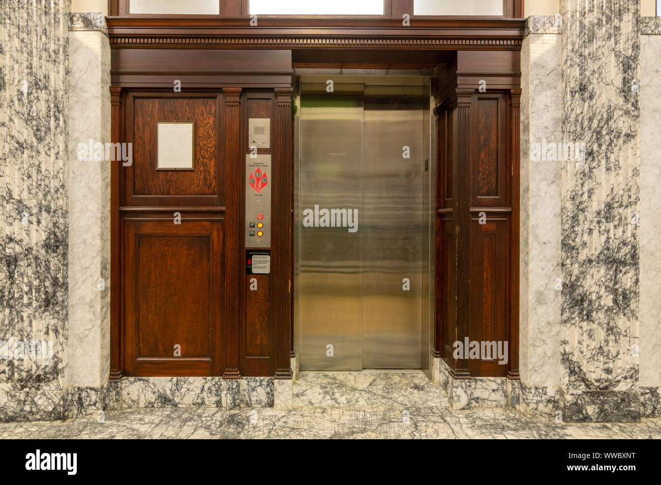 Alte Aufzug mit Metall Türen und Holzmaserung Verkleidungen Stockfoto