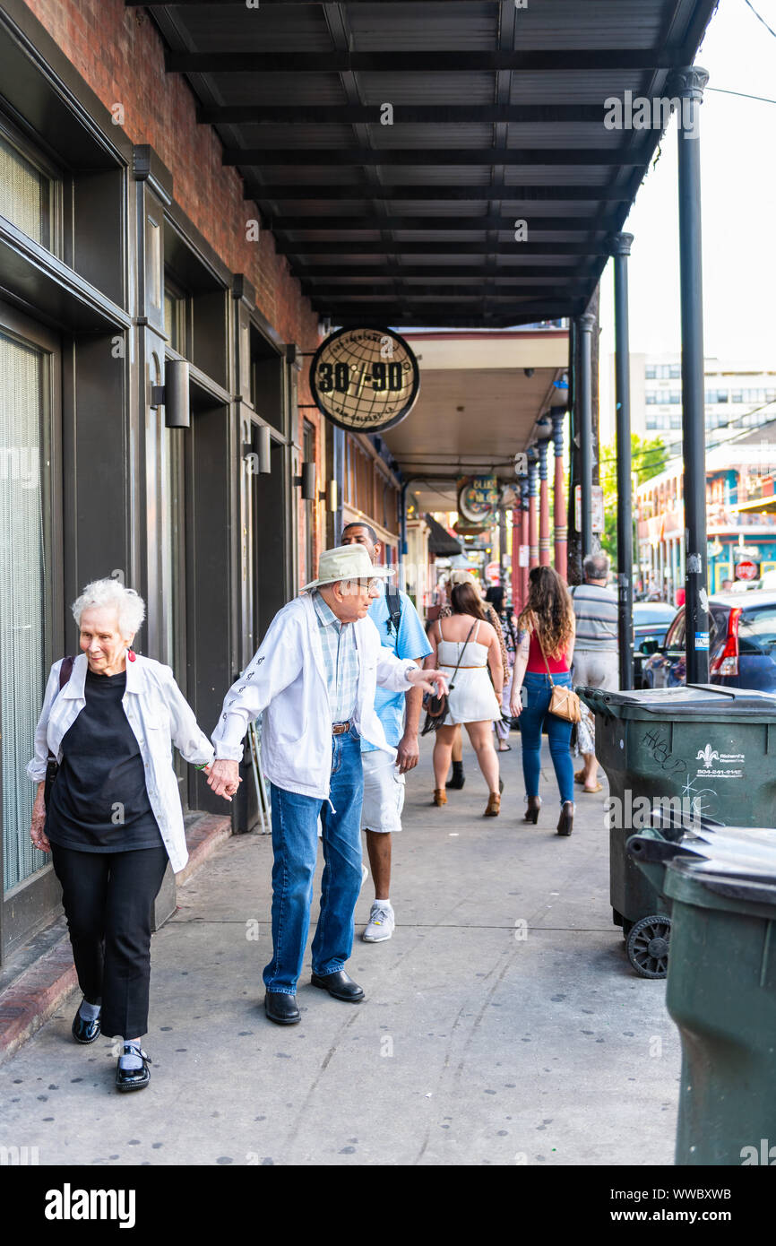 New Orleans, USA - 22. April 2018: Frenchmen Street Bürgersteig in Louisiana Altstadt Stadt mit Senior Paar, Menschen zu Fuß von Restaurants, Bars und Pu Stockfoto