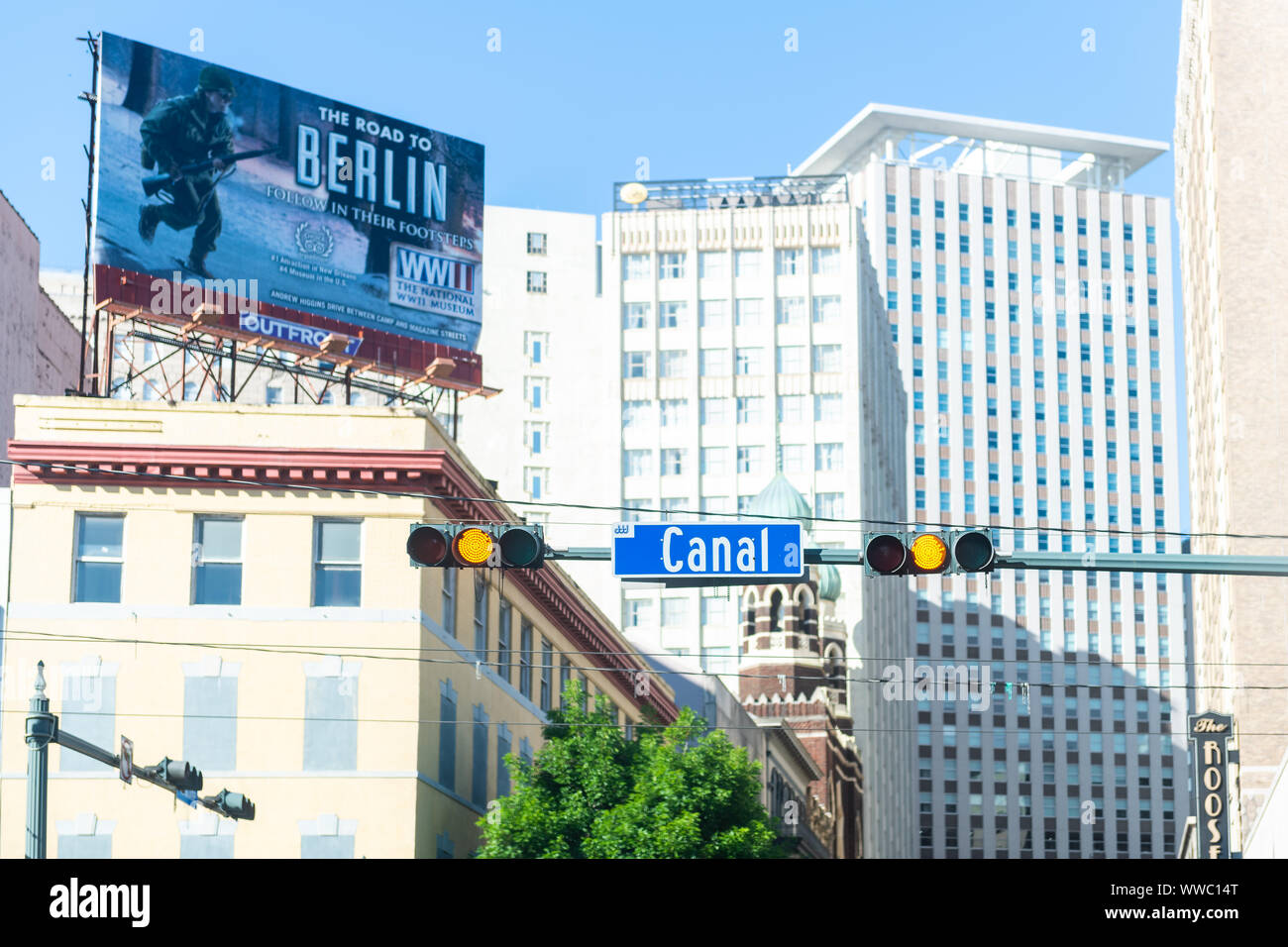 New Orleans, USA - 23. April 2018: Downtown Canal Street Sign in Louisiana berühmte Stadt an einem sonnigen Tag und an den Billboard Zeichen für WWII Museum Stockfoto