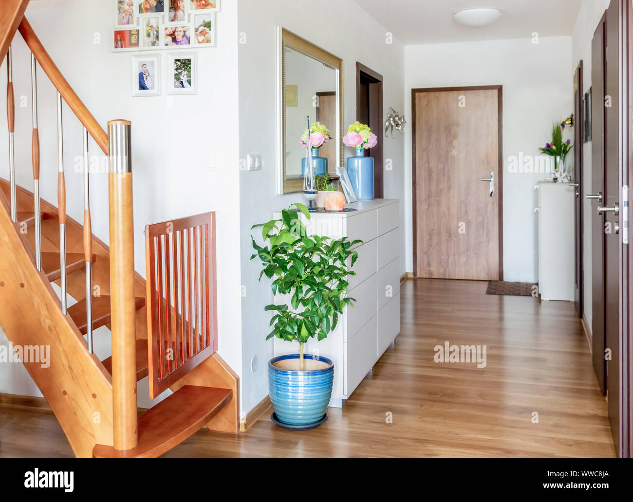 Home Flur mit Holzfußboden, weißen Möbeln und Spiegel Stockfoto