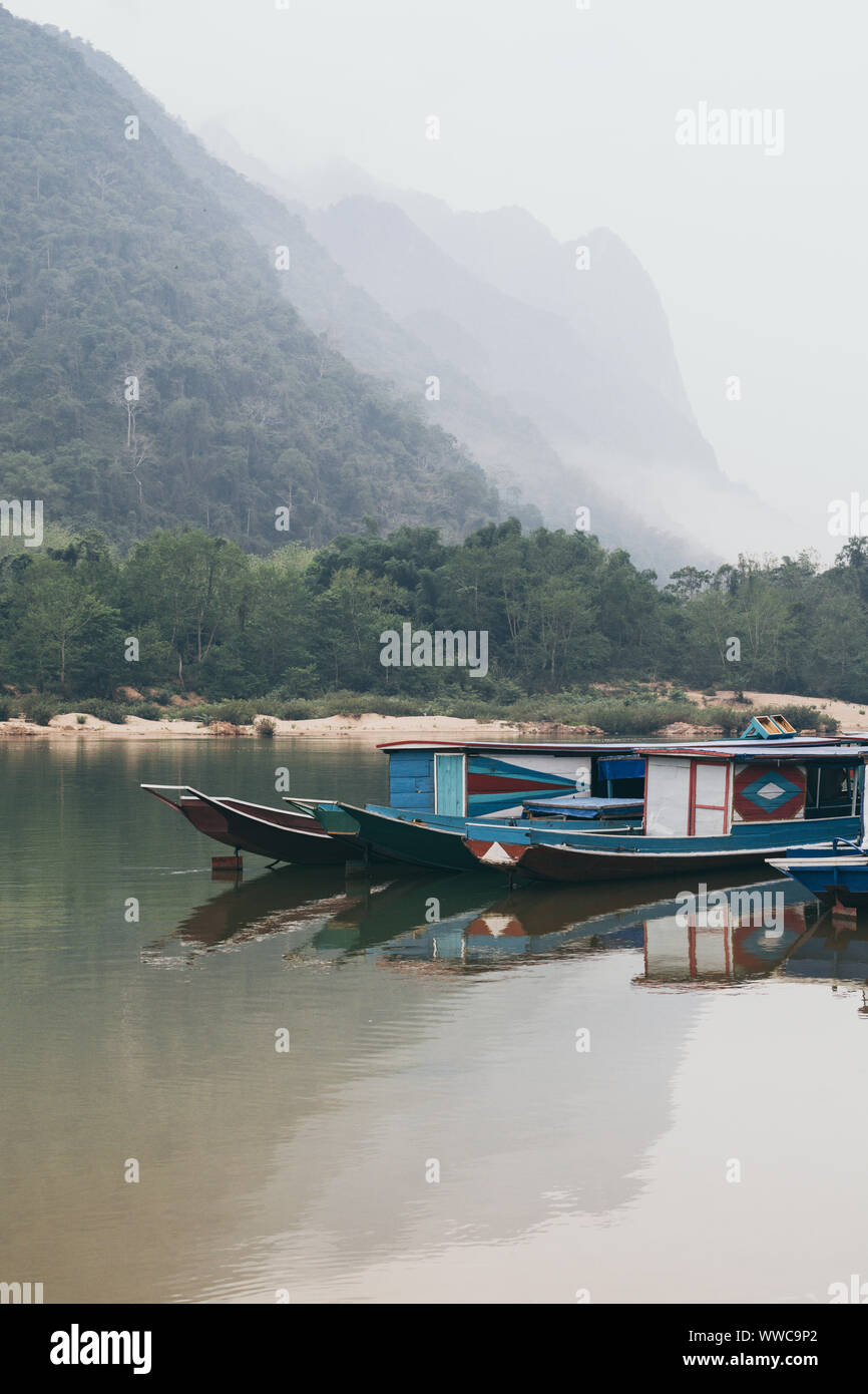 Die traditionellen laotischen Holz- Slow Boat auf Nam Ou Fluss in der Nähe von Nong Khiaw Dorf, Laos. Reflexion im Wasser Stockfoto