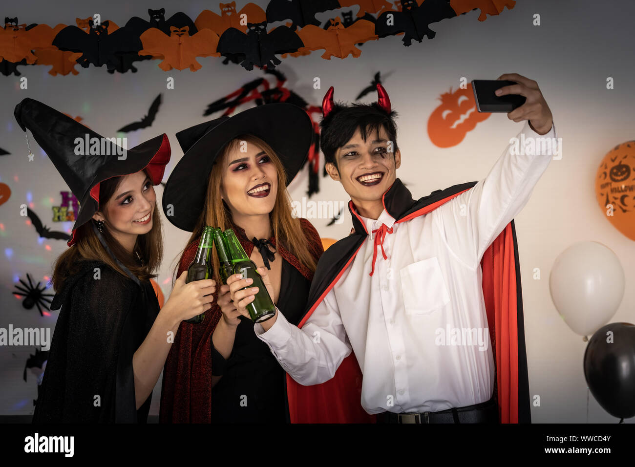 Gruppe für junge Erwachsene und jugendliche Menschen feiern eine Halloween  Party Karneval in Halloween Kostüme Alkohol trinken Bier und selfie p  Stockfotografie - Alamy