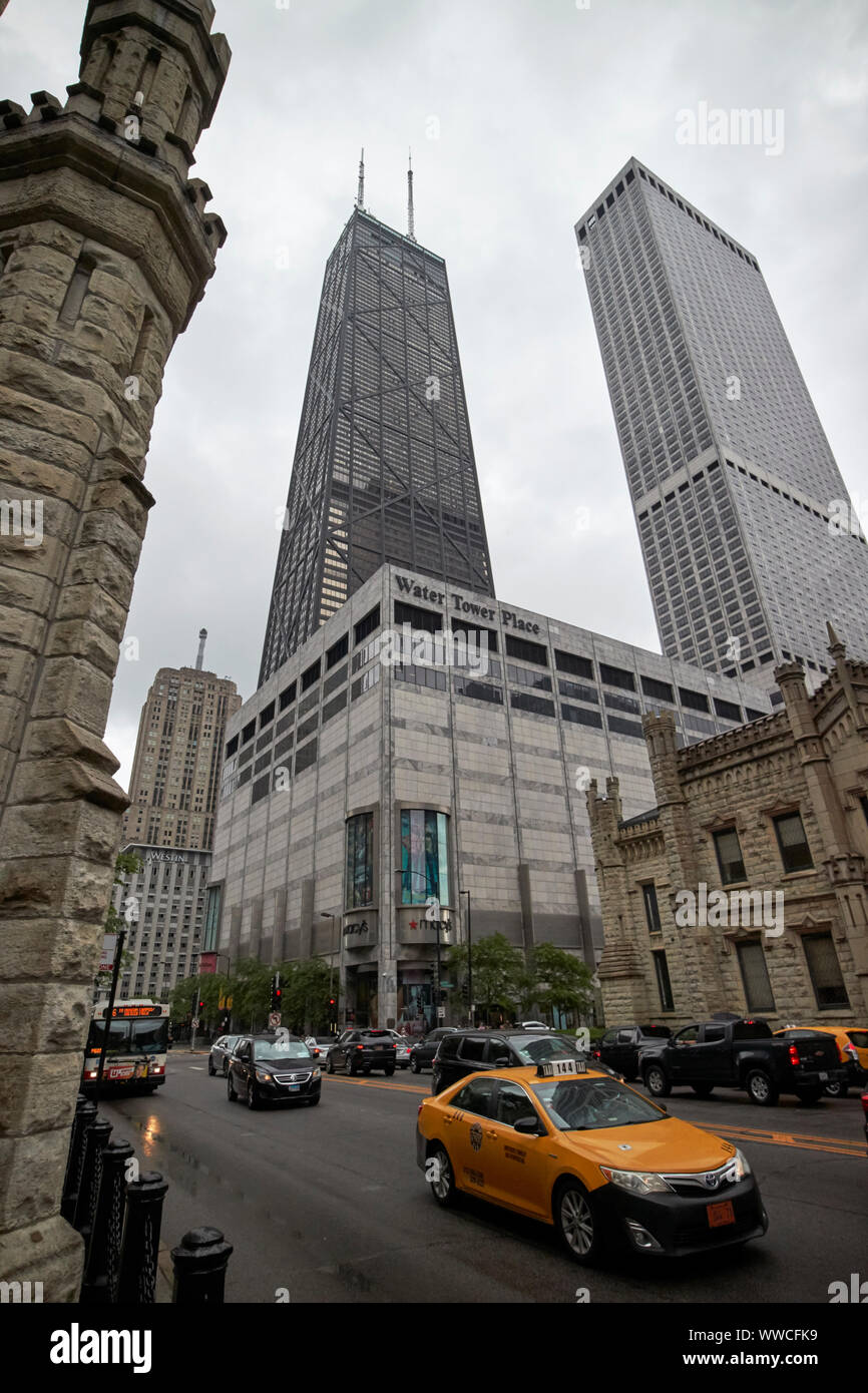 Yellow cab auf der North Michigan Avenue Magnificent Mile auf einem nassen bewölkten Tag gegen Water Tower Place und dem John Hancock Tower Chicago Illinois U Stockfoto