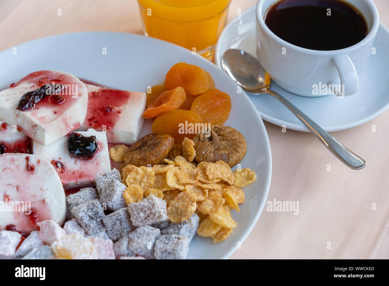 Quark gegossen, Fruchtjoghurt, getrocknete Aprikosen, Feigen, Cornflakes und Tasse Kaffee auf Tisch. Frühstück Konzept. Nahaufnahme Stockfoto