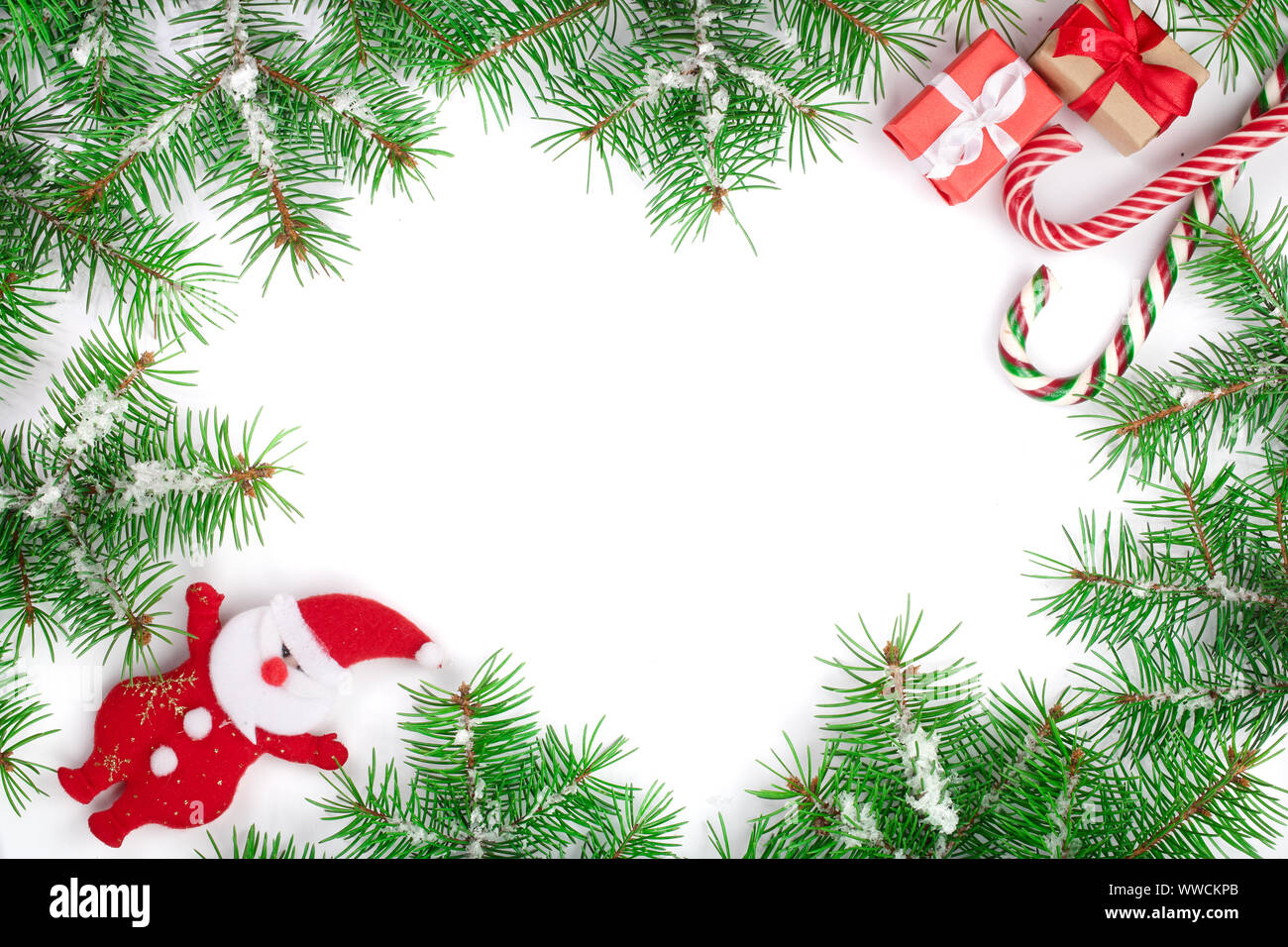 Weihnachten Rahmen der Fir Tree Branch mit Zuckerstangen und Schnee auf weißem Hintergrund mit Kopie Platz für Ihren Text isoliert. Ansicht von oben. Stockfoto