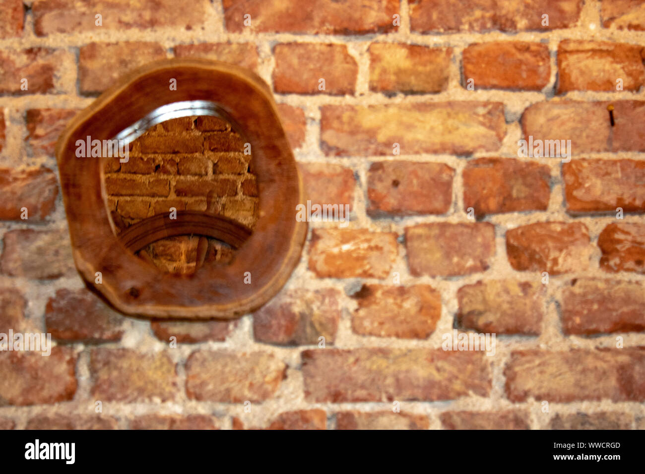 Spiegel mit Rahmen aus Holz. Alten Ziegel Wand im Hintergrund. Fokus auf den Spiegel. Stockfoto