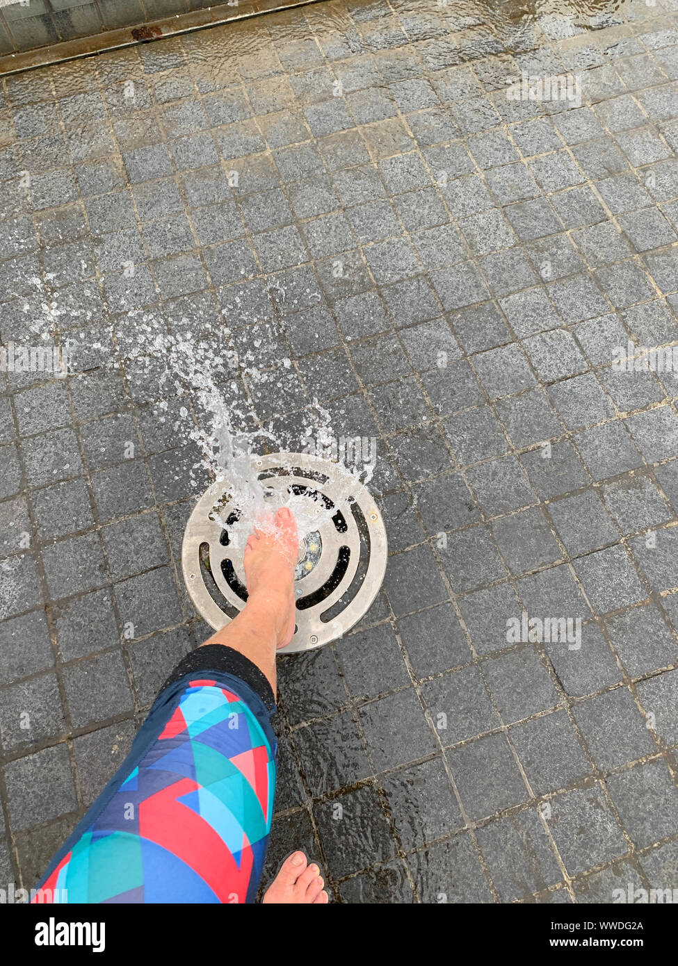 Woman's Bein über einen Springbrunnen in der Straße, Litauen Stockfoto