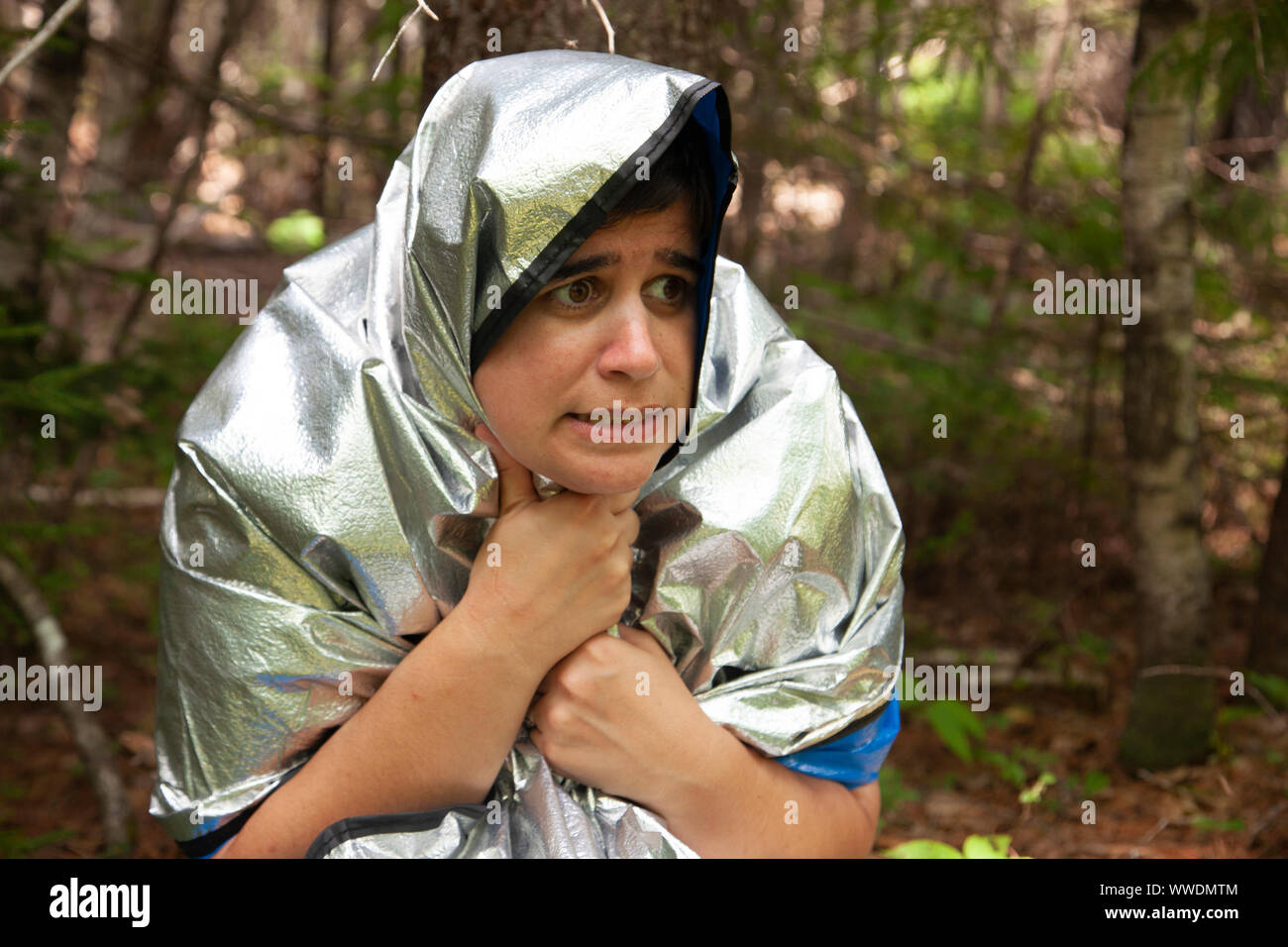 Person in eine Decke, die versuchen, warm zu halten und warten auf Rettung in den Wäldern Stockfoto