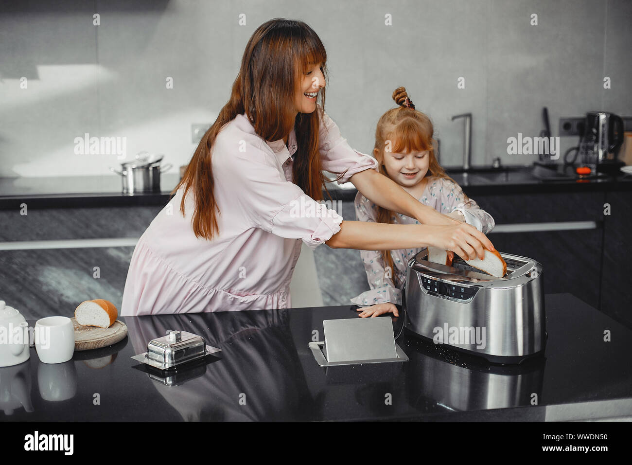 Schöne Mutter mit Tochter. Familie arbeitet in der Küche. Stockfoto