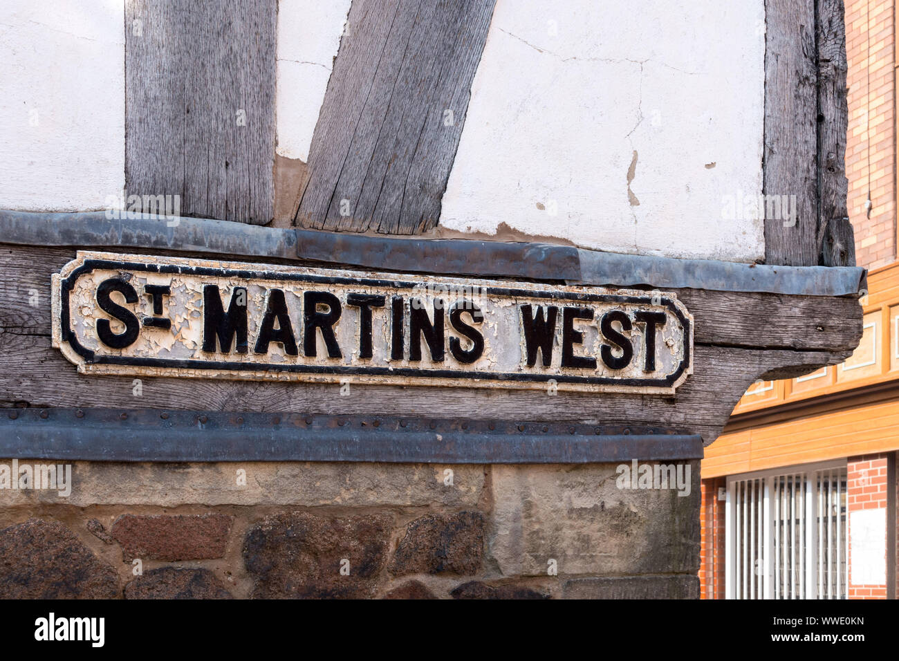 Alte gegossen Straßenschild mit schwarzer Schrift erhaben auf weißem Hintergrund an der Seite von Leicester Guildhall, St Martins West, Leicester, England, Großbritannien Stockfoto