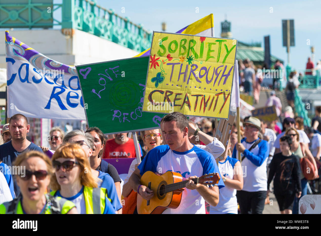 Brighton, East Sussex, UK. 15 Sep, 2019. Die Südküste recovery Spaziergang 'Cascade kreative recovery" ist eine Wohltätigkeitsorganisation, Menschen von Alkohol- oder Drogenmissbrauch bietet es eine freundliche und unterstützende Umgebung für Menschen direkt in Abhängigkeit beteiligt zu erholen. Slogans gehören obriety durch Kreativität und Nüchternheit ist gesund' als Gruppen von Menschen entlang der Strandpromenade entfernt. © Paul Lawrenson 2019, Foto: Paul Lawrenson/Alamy leben Nachrichten Stockfoto