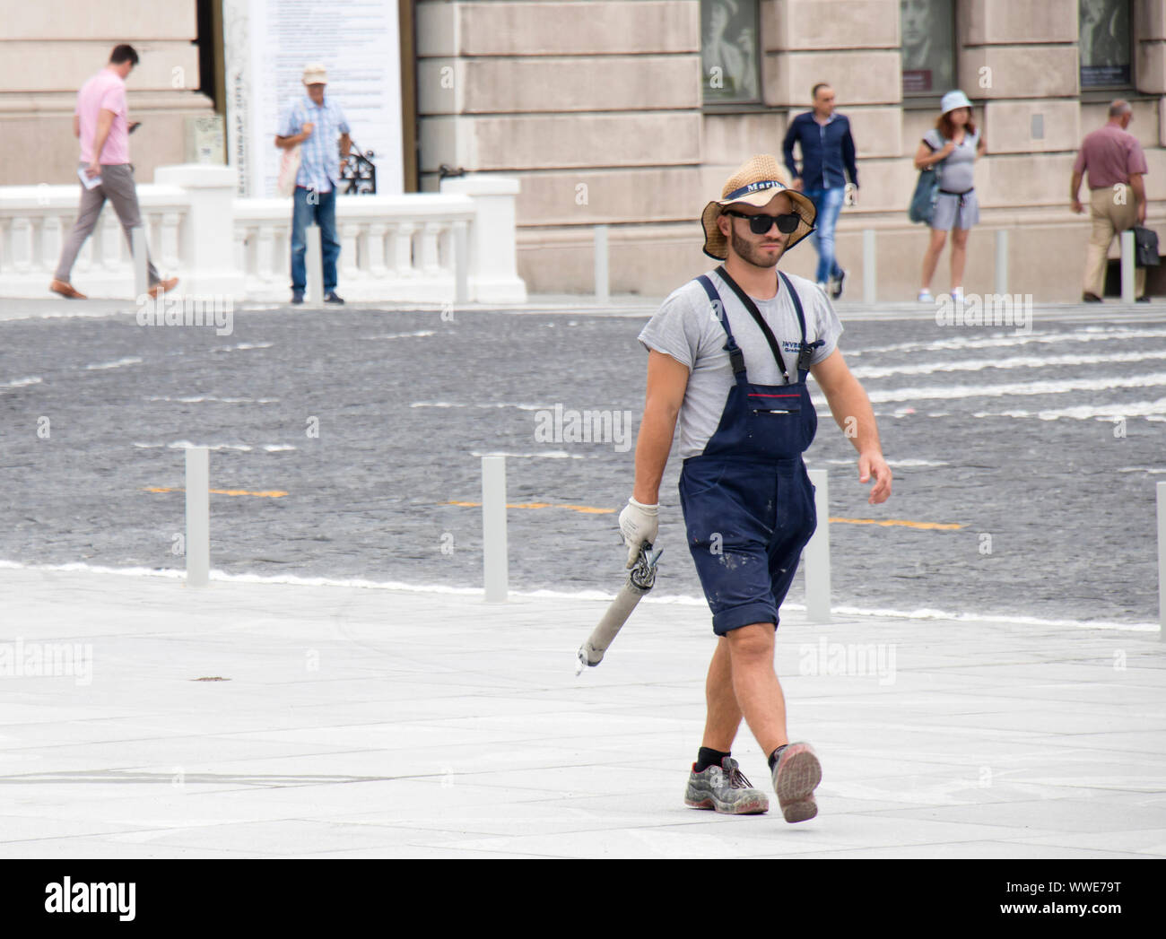 Belgrad, Serbien - 3. September 2019: Junge und schöne Bauarbeiter in lässigen Sommer-outfit auf Stadt Pflaster mit einer Kartuschenpistole Stockfoto