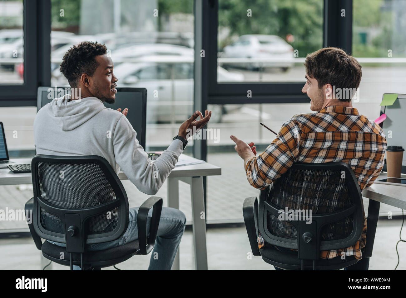 Zwei junge multikulturelle Programmierer Gestik beim Gespräch im Büro Stockfoto
