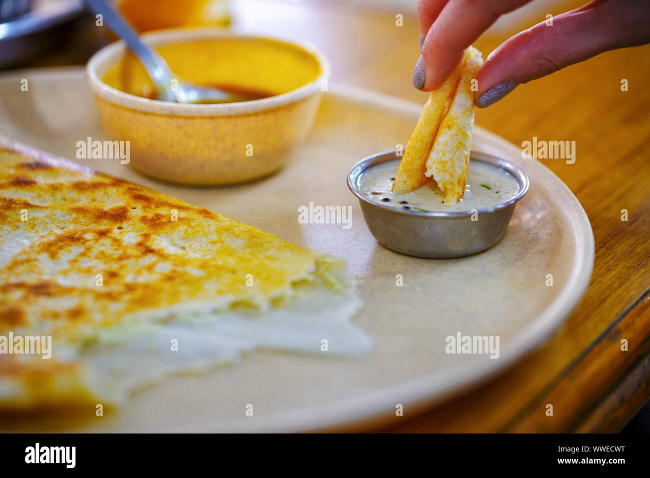 Dosa. Populäre Südindische Speisen. Mädchen isst Dosa, close-up Stockfoto