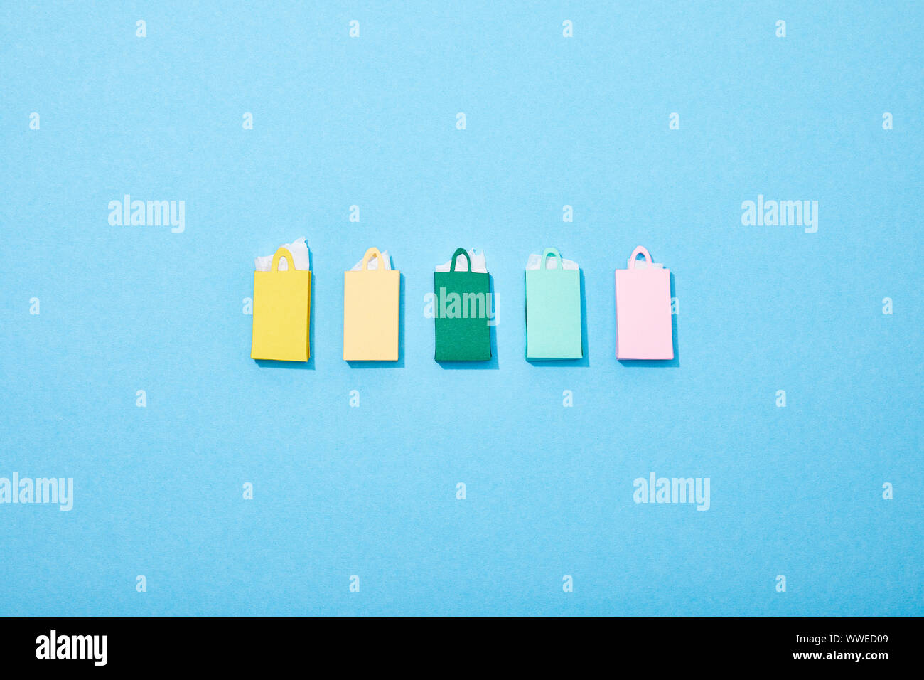 Flach mit bunten Papier Einkaufstüten auf Blau Stockfoto