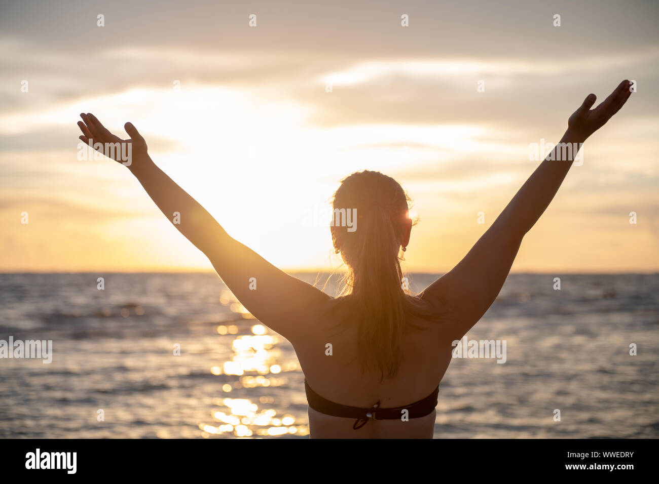 Junge Frau am Strand bei Sonnenuntergang in Florida suchen, USA Stockfoto