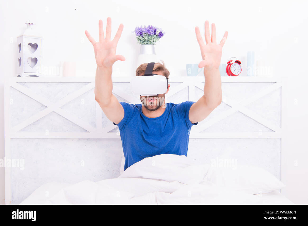 Die beste VR-Erfahrung. Hübscher Kerl tragen VR-Headset im Bett. Kaukasische Mann mit VR-Brille im Schlafzimmer. Immersive rendern in VR. Stockfoto