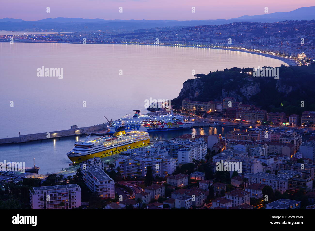Nizza, Frankreich-16 Apr 2018 - Sonnenuntergang Blick auf eine Fähre von Corsica Sardinia Ferries im Hafen von Nizza und der Promenade des Anglais am Wasser auf. Stockfoto