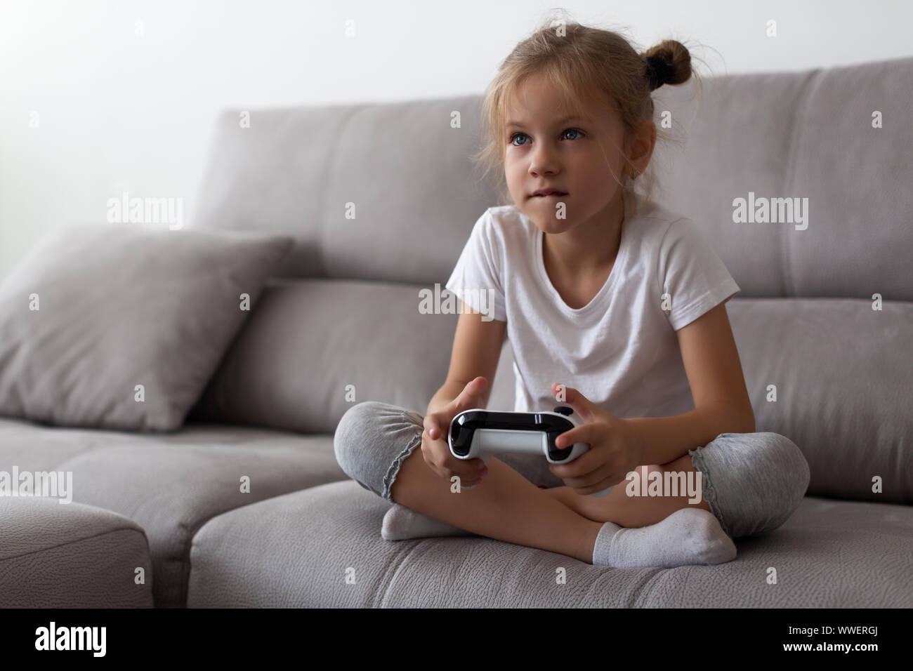 Schwere kleine Mädchen spielen Videospiele zu Hause Stockfoto