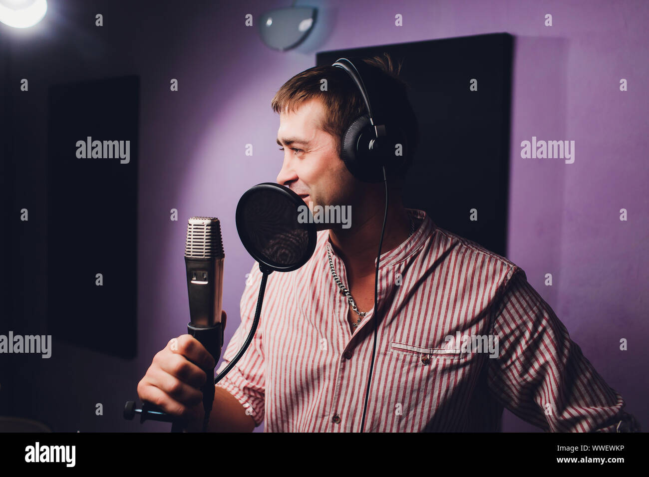 Musik, Show business, Menschen und Voice-Konzept - männliche Sänger mit  Kopfhörer und Mikrofon singen Song bei Sound Recording Studio  Stockfotografie - Alamy