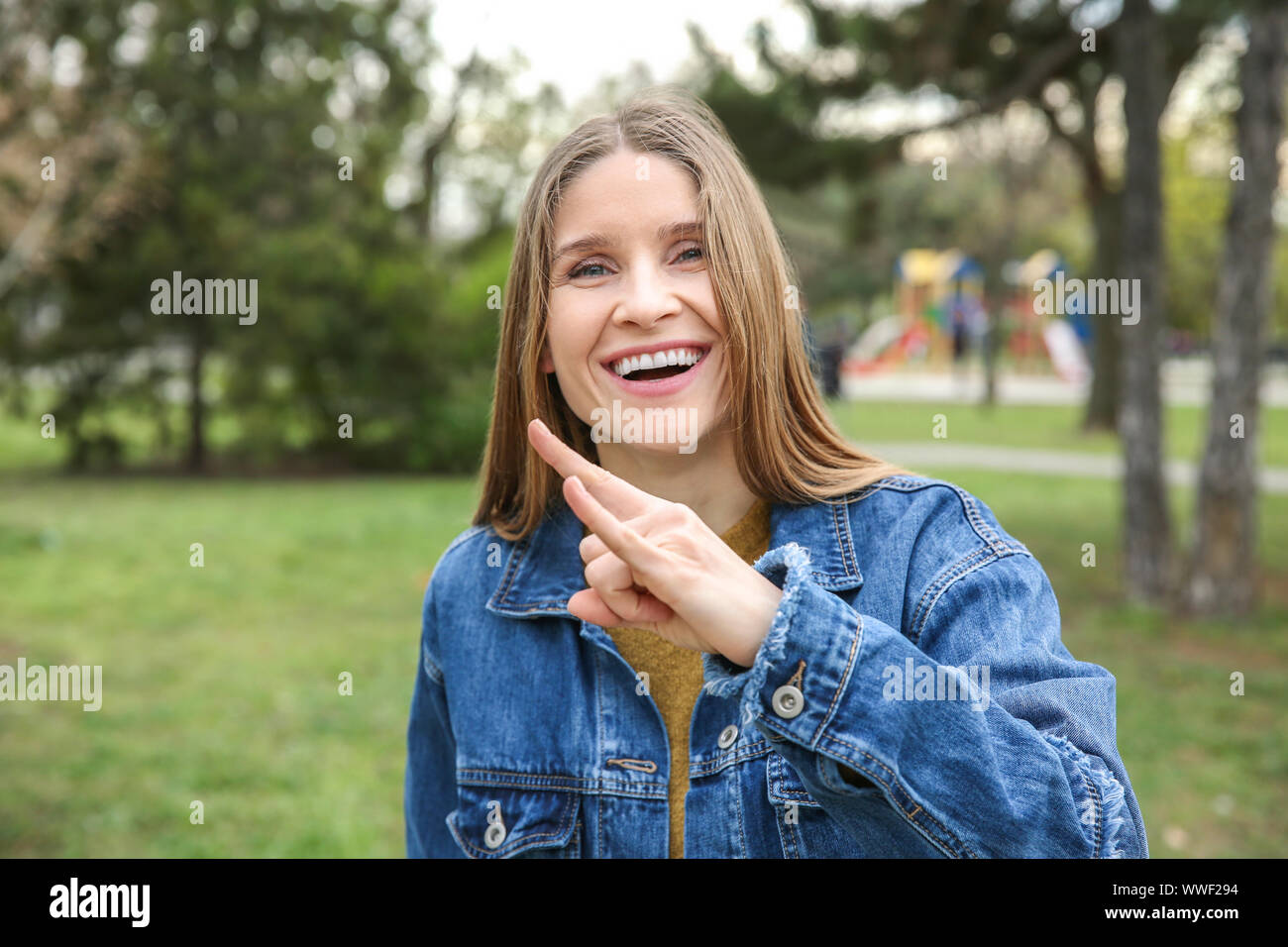 Junge taubstumme Frau, die Gebärdensprache im Freien Stockfoto