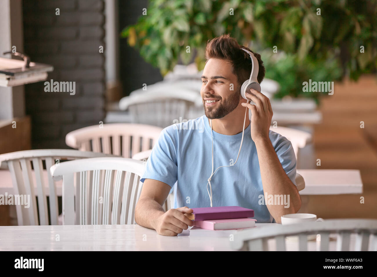 Junger Mann hören in Cafe zu Hörbuch Stockfoto