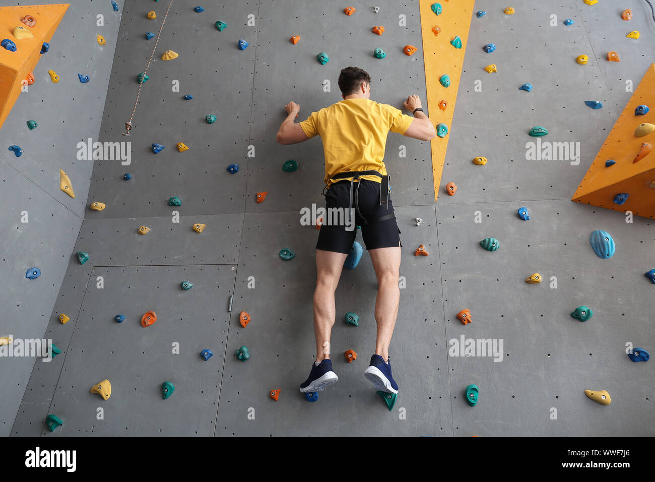 Junger Mann Kletterwand in der Turnhalle Stockfoto