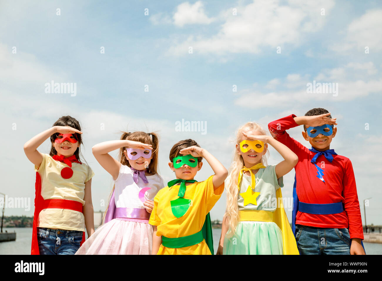 Süße kleine Kinder als Superhelden im Freien gekleidet Stockfoto