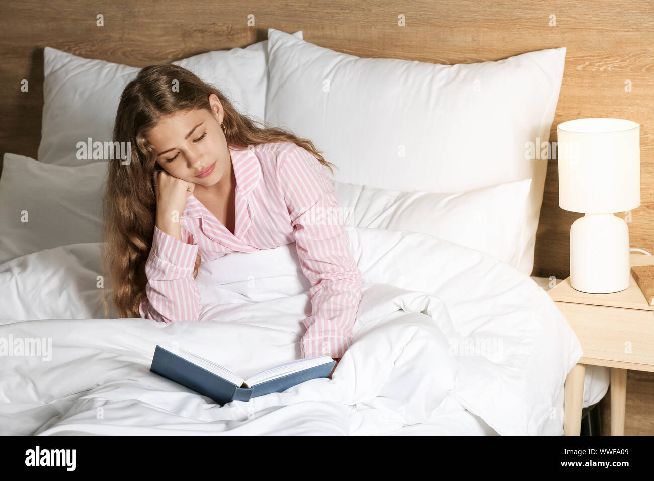 Junges Mädchen Lesung buchen Sie nachts im Bett Stockfoto