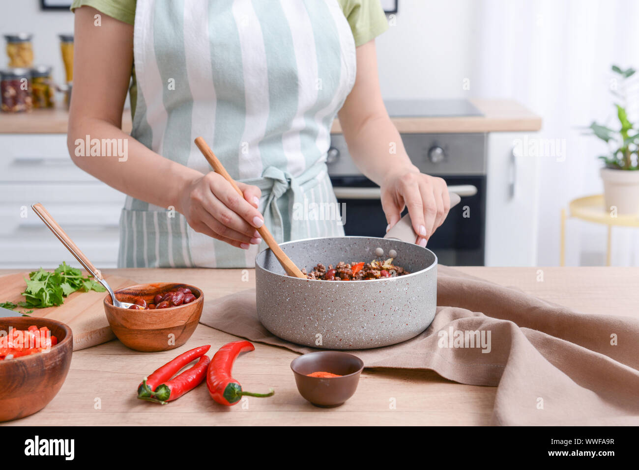 Frau kochen traditionelle Chili con carne in der Küche Stockfoto