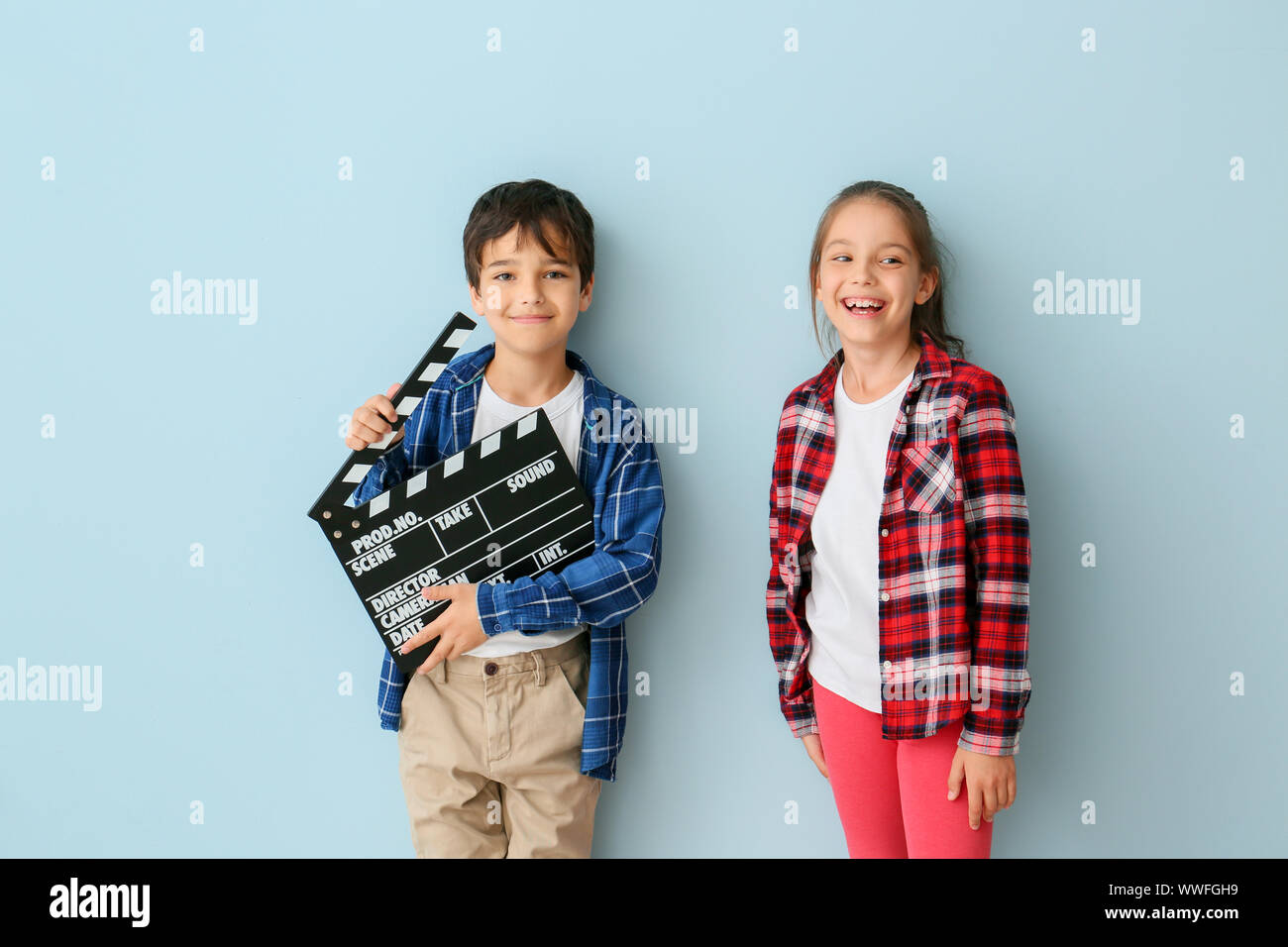 Süße kleine Kinder mit filmklappe auf farbigen Hintergrund Stockfoto