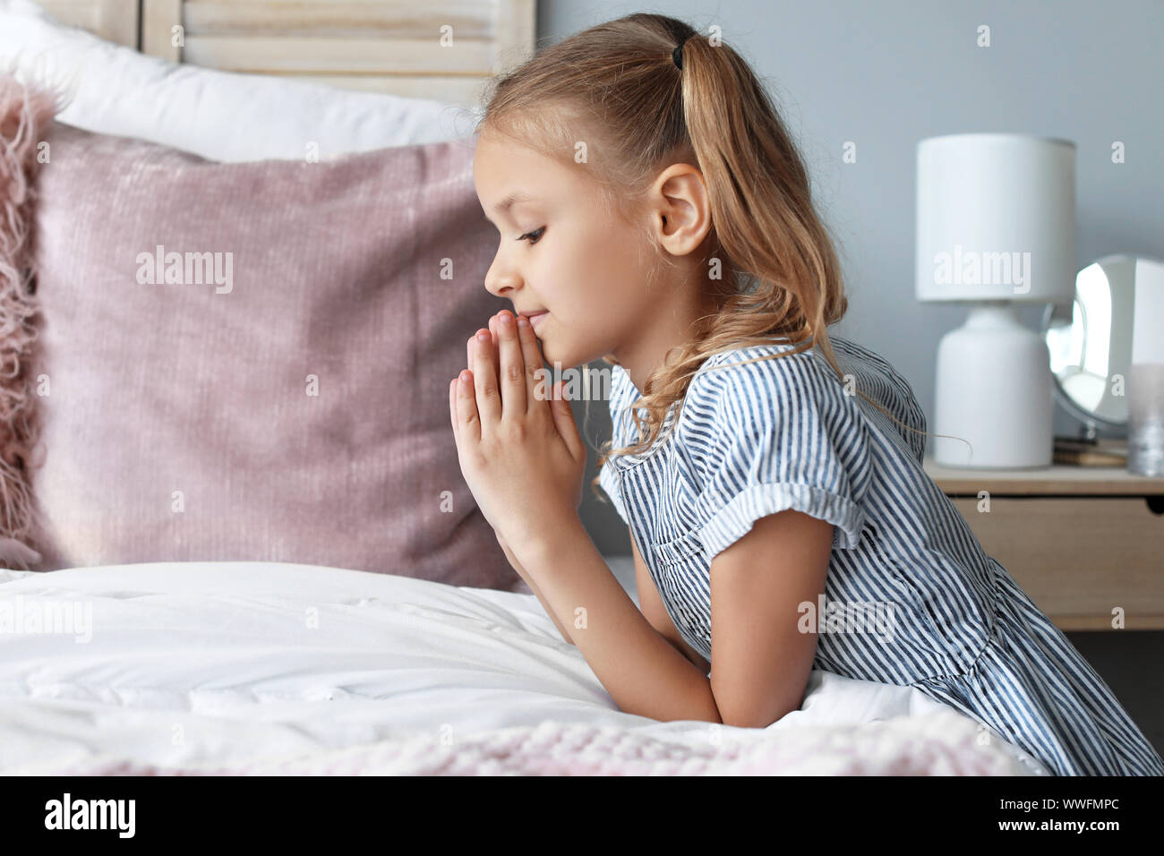 Süße kleine Mädchen beten im Schlafzimmer Stockfoto
