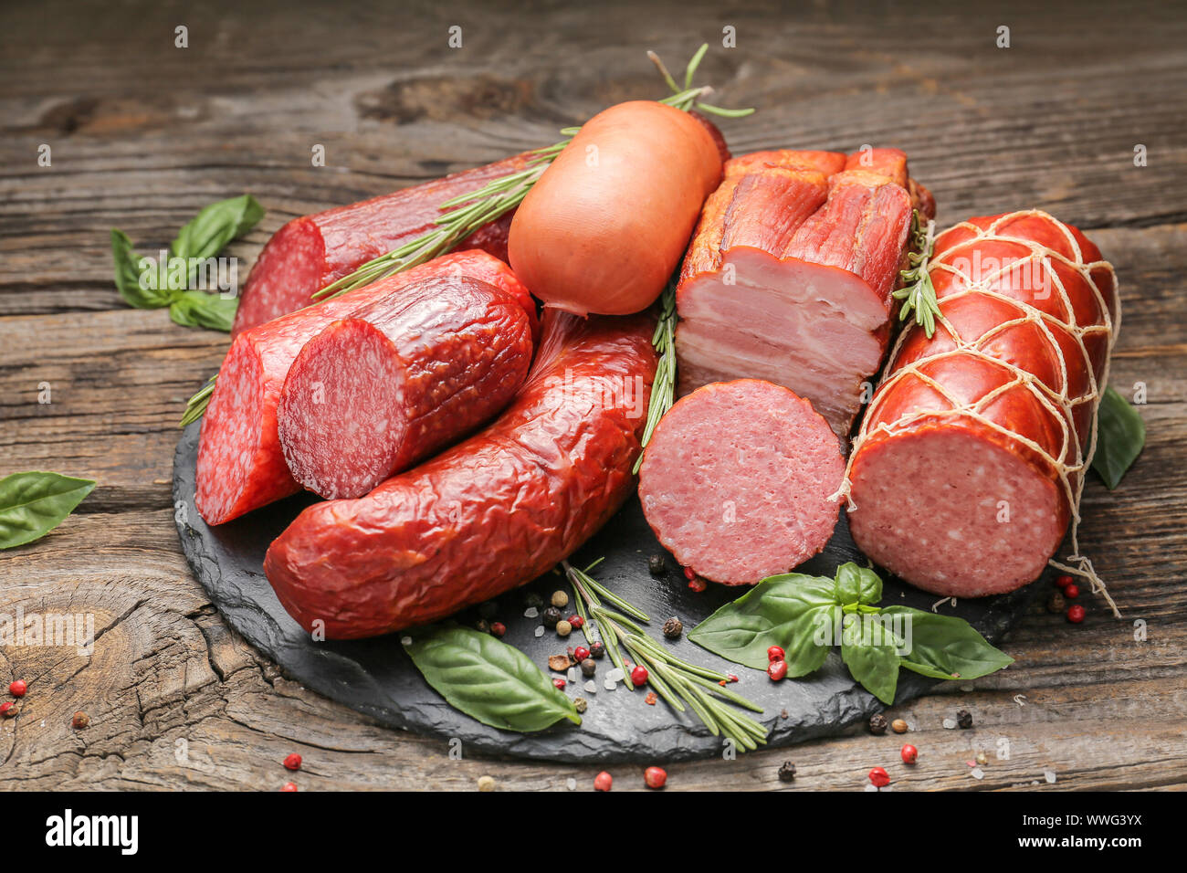 Schiefer Platte mit Auswahl an Würstchen auf hölzernen Tisch Stockfoto